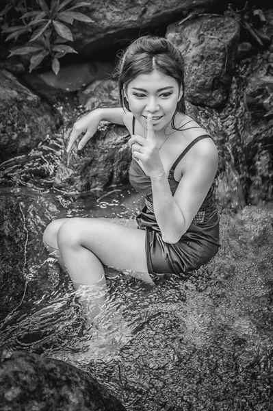 Asia Hermosa joven sentada en la caída del agua — Foto de Stock