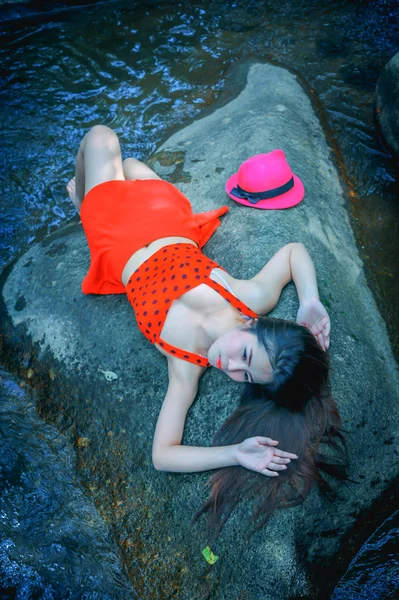 Asia bella giovane ragazza sexy sdraiata su una roccia — Foto Stock