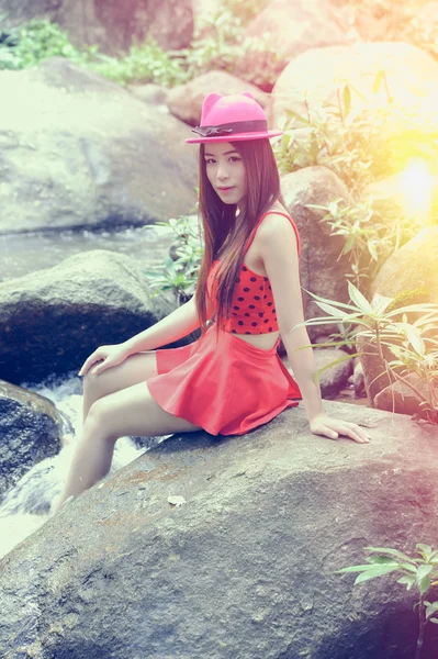 亚洲美丽年轻的女孩坐在岩石上 — 图库照片