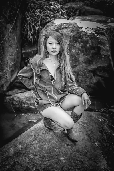 Asia Beautiful young girl sitting on the rock