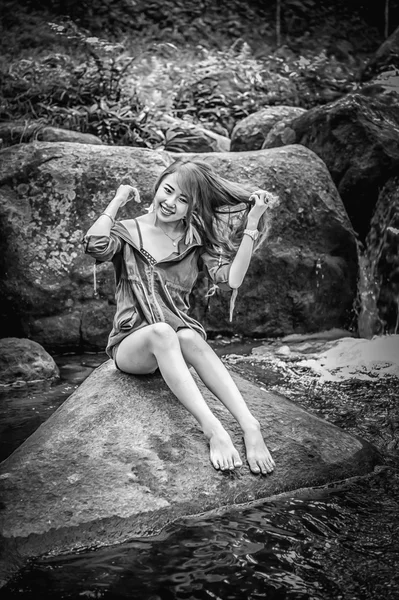 Asia Beautiful young girl sitting on the rock — Stock Photo, Image