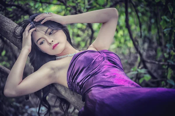 Asia Pretty girl lying on tree — Stock Photo, Image