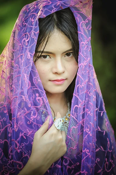 Asia beautiful lady covered in violet fabrics — Stock Photo, Image