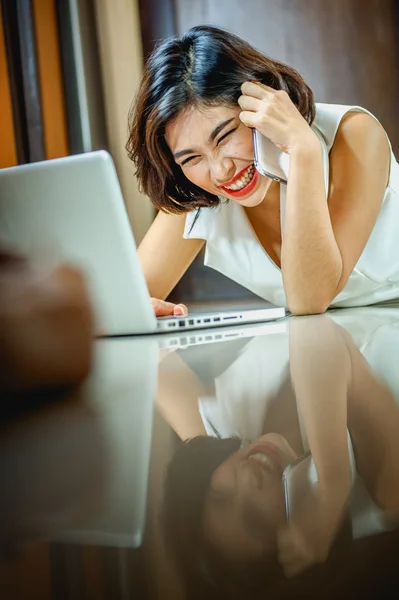 Mujer de Asia con teléfono inteligente y portátil tumbado en el suelo — Foto de Stock