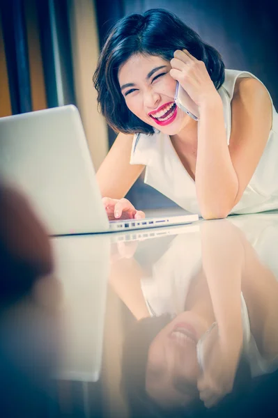 Asia mujer usando el teléfono inteligente y portátil tumbado en el suelo — Foto de Stock