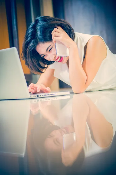 Mujer de Asia con teléfono inteligente y portátil tumbado en el suelo — Foto de Stock