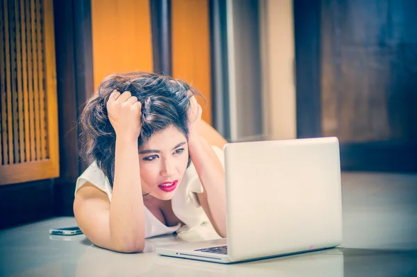 Ásia mulher deitada no chão e usando laptop — Fotografia de Stock