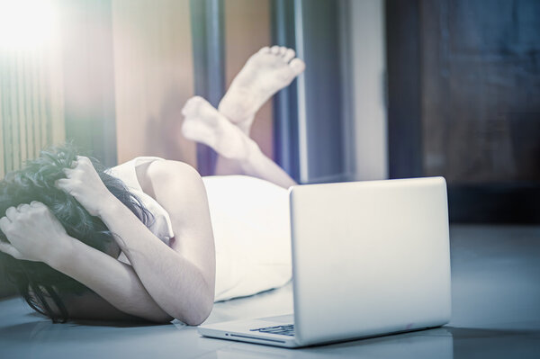 asia woman lying on floor and using laptop