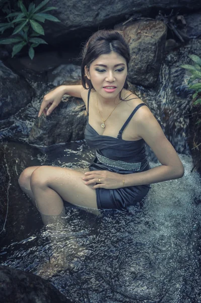 Asia Hermosa joven sentada en la caída del agua — Foto de Stock