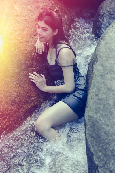 Asia Hermosa joven sentada en la caída del agua — Foto de Stock