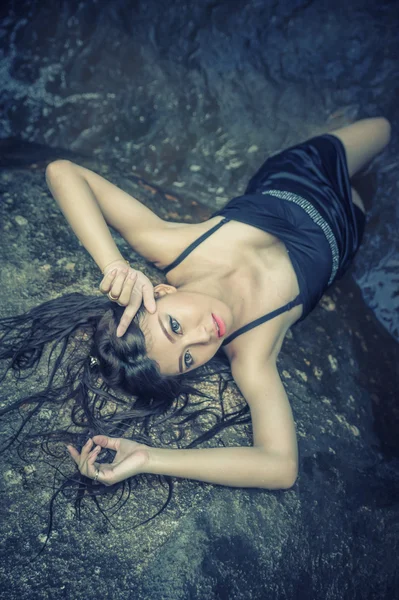 Asya güzel genç seksi kız kayanın üzerinde uzanmış — Stok fotoğraf