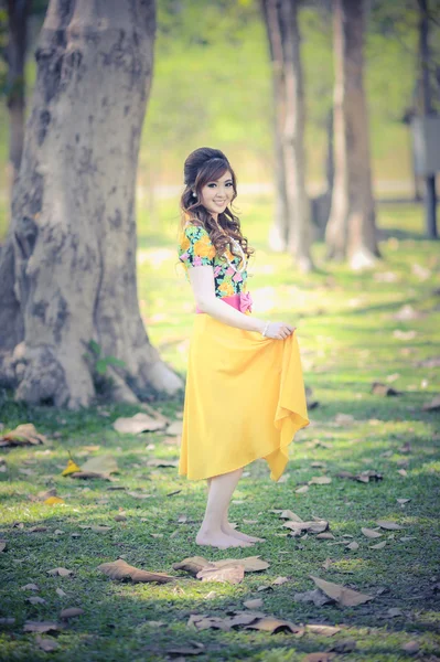 Ásia menina bonita no vestido amarelo — Fotografia de Stock