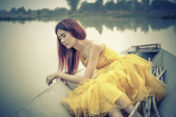 Asia Hermosa mujer en vestido amarillo sentarse en el barco — Foto de Stock