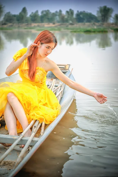 Asia piękna kobieta w żółtej sukience siedzieć na łodzi — Zdjęcie stockowe