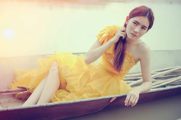 Asia piękna kobieta w żółtej sukience siedzieć na łodzi — Zdjęcie stockowe