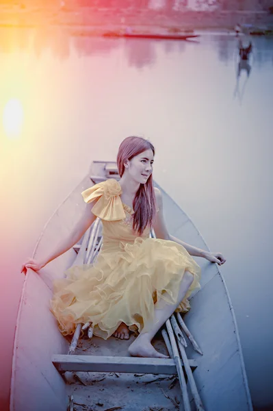 黄色のドレスで美しいアジア女性が船の上に座る — ストック写真