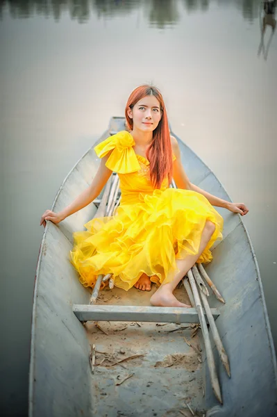 Азія красива жінка в жовте плаття сидіти на човні — стокове фото