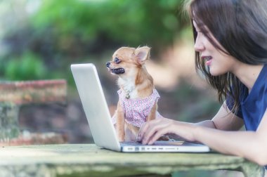 Onu köpek ve dizüstü olan mutlu kadın 