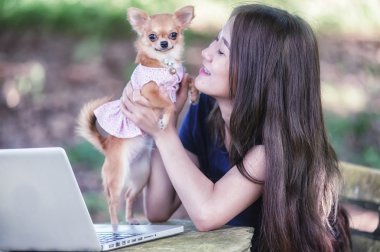 Onu köpek ve dizüstü olan mutlu kadın 