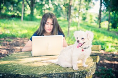 Onu köpek ve dizüstü olan mutlu kadın 