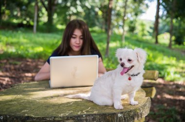 Onu köpek ve dizüstü olan mutlu kadın 