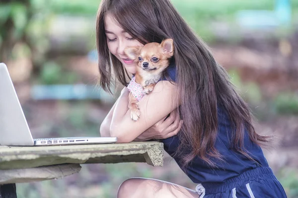 Onu köpek ve dizüstü olan mutlu kadın 