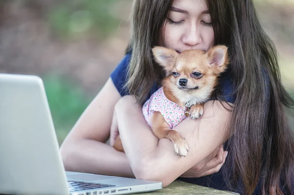 Onu köpek ve dizüstü olan mutlu kadın 