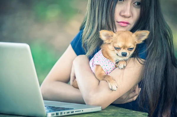 Onu köpek ve dizüstü olan mutlu kadın 
