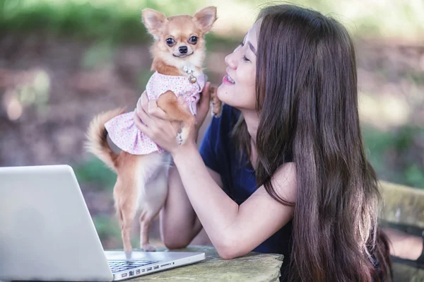 Onu köpek ve dizüstü olan mutlu kadın 