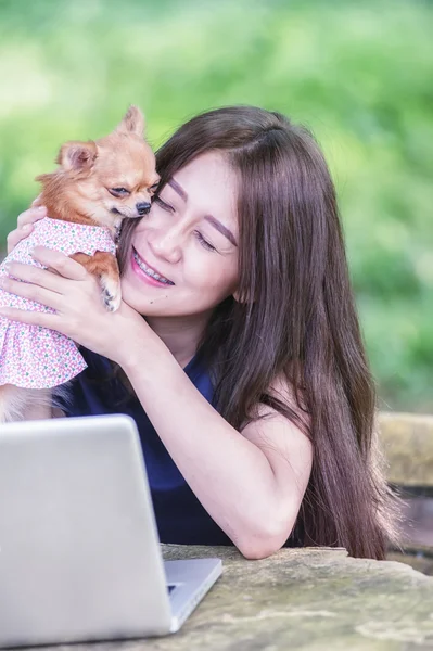 Onu köpek ve dizüstü olan mutlu kadın 