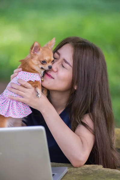 Onu köpek ve dizüstü olan mutlu kadın 