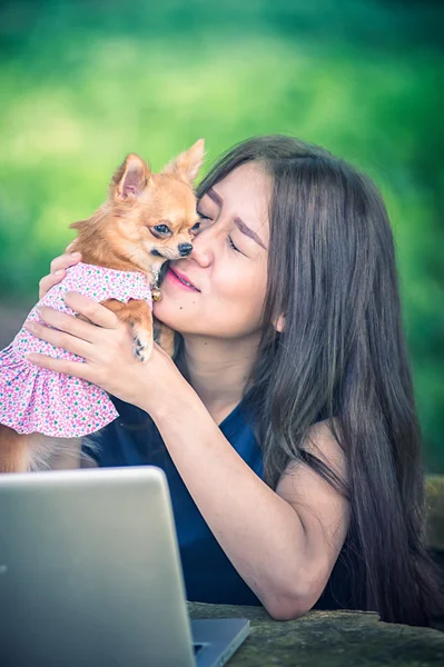 Onu köpek ve dizüstü olan mutlu kadın 