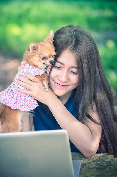Onu köpek ve dizüstü olan mutlu kadın 