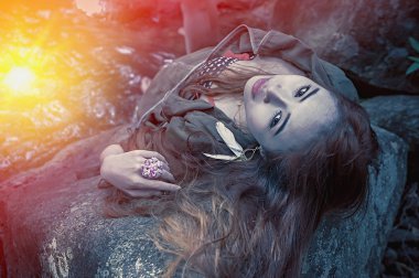 Asya güzel genç seksi kız kayanın üzerinde uzanmış