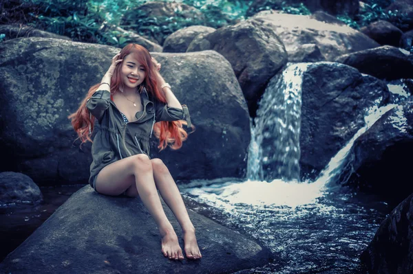 Asia Beautiful young girl sitting on the rock — Stock Photo, Image