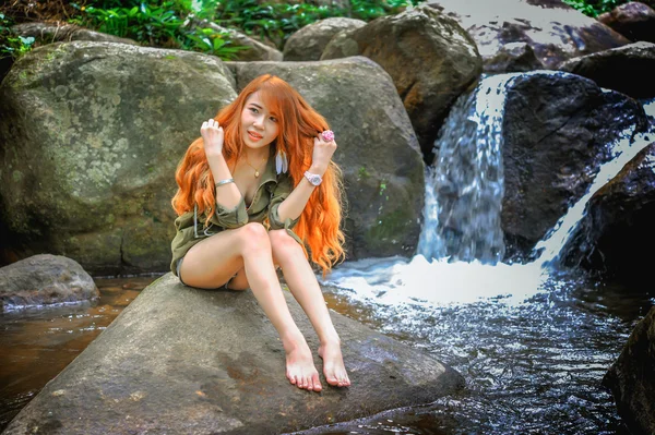 Asia Beautiful young girl sitting on the rock — Stock Photo, Image