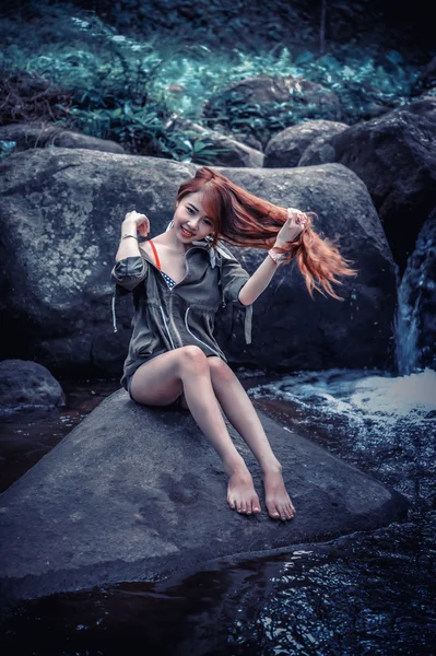 바위에 앉아 아시아 아름 다운 젊은 여자 — 스톡 사진
