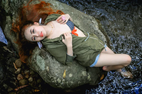 Asia beautiful young sexy girl lying down on a rock — Stock Photo, Image