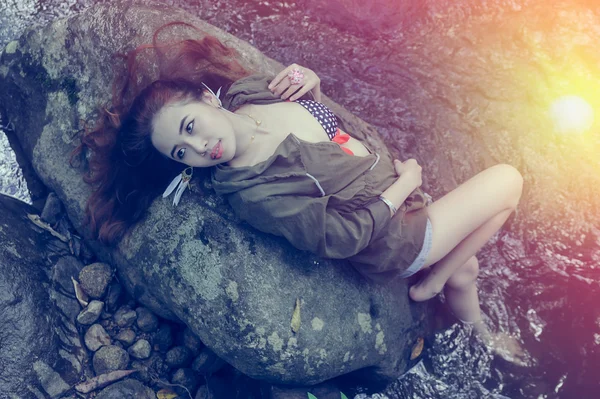 Asia beautiful young sexy girl lying down on a rock — Stock Photo, Image