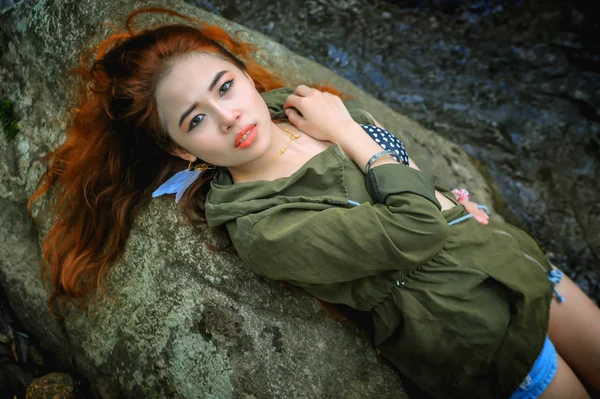 亚洲年轻漂亮性感的女孩躺在岩石上 — 图库照片