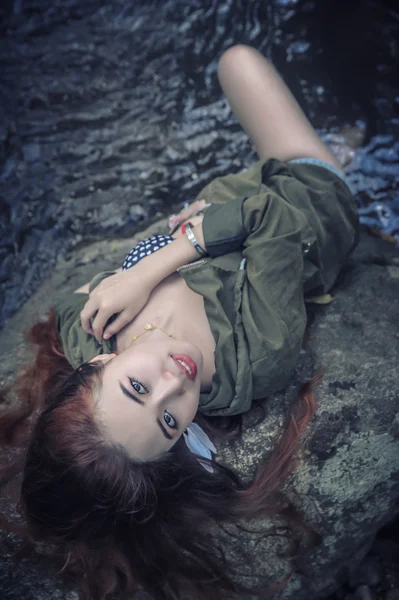 Asia beautiful young sexy girl lying down on a rock — Stock Photo, Image