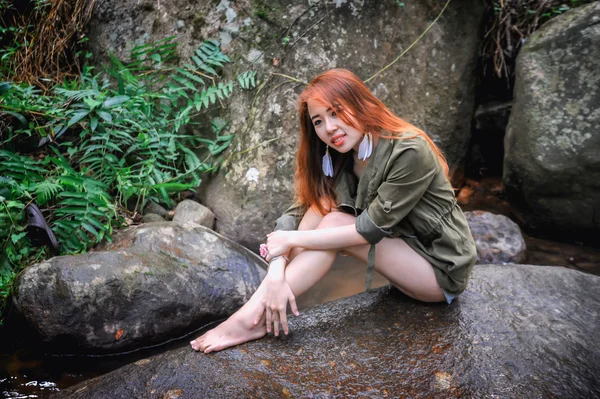 Ασία όμορφη νεαρή κοπέλα που κάθεται σε βράχο — Φωτογραφία Αρχείου