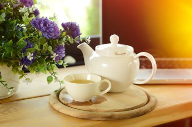 Kupası, çay potu, kurabiye ve ahşap masa laptop