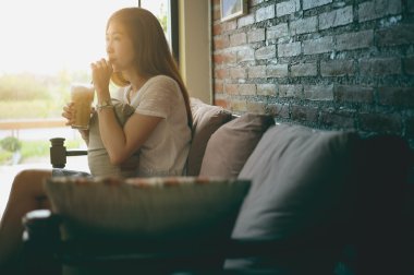 kahve dükkanında kanepede oturan Asya kadın