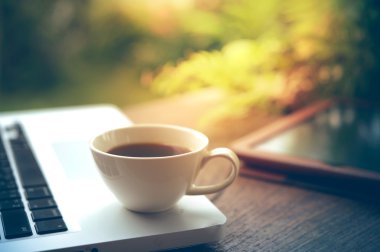 Dizüstü bilgisayar, tablet, smartphone ve beyaz fincan kahve ahşap tablo.