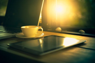 Dizüstü bilgisayar, tablet, smartphone ve beyaz fincan kahve ahşap tablo.