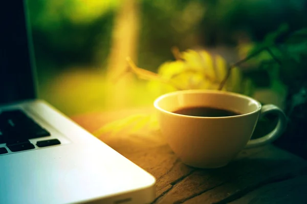 Taza de café y portátil en mesa de madera. — Foto de Stock