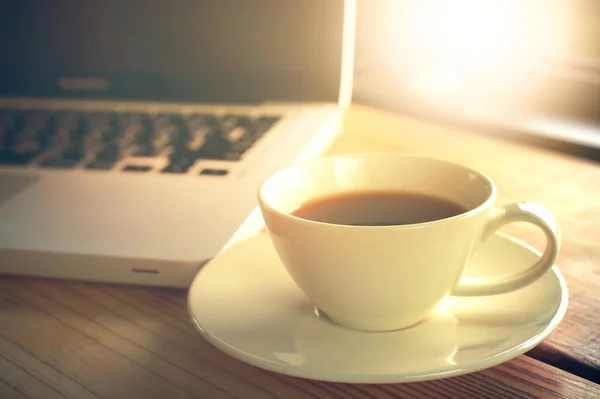 Kannettava tietokone ja kahvi kuppi kahvilassa — kuvapankkivalokuva