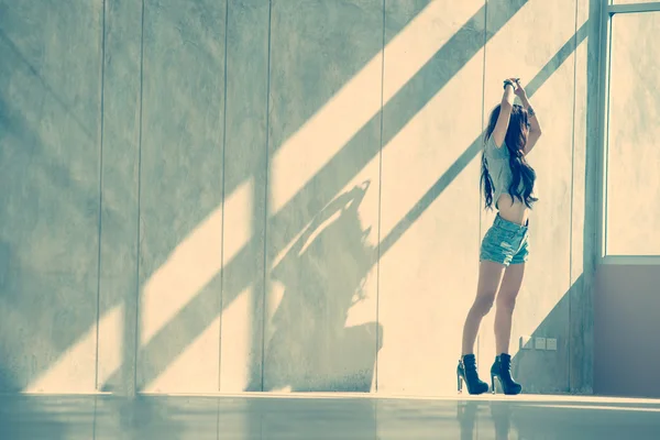 Fashion portrait of young model posing by the wall — Stock Photo, Image