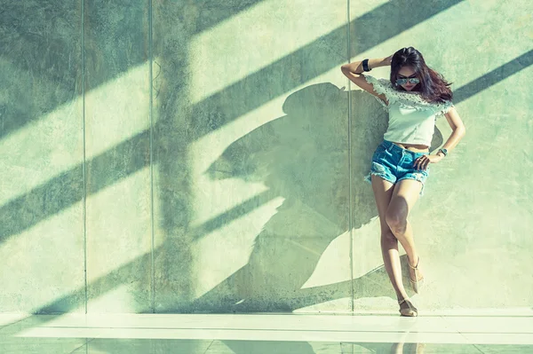 Fashion portrait of young model posing by the wall — Stock Photo, Image